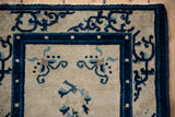 Antique Chinese Peking rug corner, ivory ground with cobalt blue border and scrolling floral motifs.
