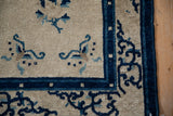 Detail of the antique Peking rug's side cord and vivid blue curvilinear motifs.