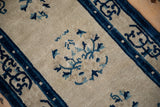 Aged ivory field and cobalt blue border detail with nuanced stylized floral patterns.