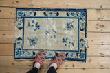 Detailed view of antique Peking rug: platinum field, cobalt blue floral motifs, visible foundation wear.