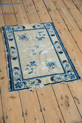 Antique Peking rug corner detail: cobalt, sky blue lotus border, ivory field, wear to pile.