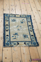Corner detail of antique Chinese Peking rug, with cobalt blue lotus border and tattered end.