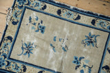 Antique Peking rug: visible foundation wear, tattered edge, platinum and blue floral motifs.
