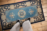Cobalt blue cloud band motifs on the beige border of an antique Chinese Peking rug.