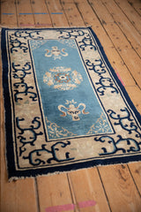 Antique Peking rug showing sky blue field, intricate floral roundel, and arabesque border.