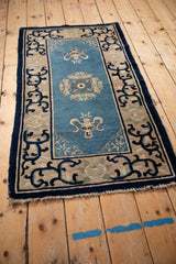 Corner of antique Chinese Peking rug, cobalt blue arabesque border, dusty blue floral field.