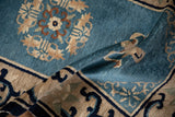 Chinese Peking rug pile texture with dusty blue and ivory floral motifs.