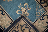 Antique Chinese Peking rug folded corner: dusty blue pile, nuanced blossom border, fringe.