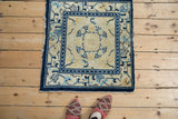 Peking rug corner, cobalt blue geometric arabesque border, cream field, powder blue motifs, tattered fringe.
