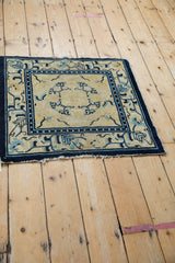 Tattered fringe and geometric arabesque border on antique Peking rug, cream and cobalt blue.