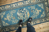 Antique Peking runner's sky blue field, worn floral designs, and Running T border.