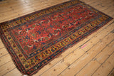 Angled, full-length view of the antique Kurdish Bijar rug's geometric Herati pattern.