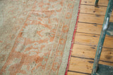 Vintage Oushak carpet edge with antique ivory, softened orange pattern, and red selvedge.