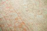 Oushak carpet displaying its soft wool pile, antique ivory, and sprawling orange motifs.