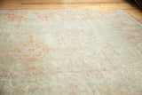 Traditional Oushak carpet showing antique ivory field, softened orange motifs, and wool texture.