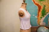 Side view of Vintage 70s white knit cropped top with chevron texture.