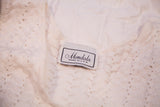Mondala brand tag on vintage white knit cropped top, showing textured pattern.
