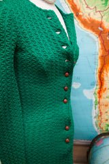 Textured emerald green vintage dress fabric with brown wooden buttons.