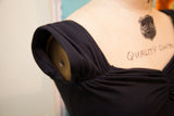 Betsey Johnson black dress with gathered shoulder and ruched bodice detail.
