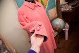 Vintage pink wool coat cuff with decorative buttons and contrasting purple interior lining.