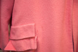Close-up of the pink wool coat's pocket, highlighting the soft fabric texture.