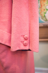 Two matching fabric-covered buttons on the soft wool cuff of the pink Versace coat.