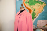 Vintage pink wool coat collar with its high single button and subtle purple detailing.