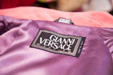 The Gianni Versace Couture label sewn onto the silky purple lining of the pink coat.