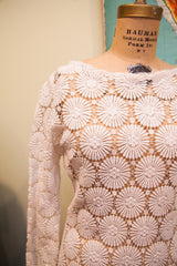 Bohemian white crocheted lace dress displaying intricate circular floral motifs.