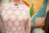 Intricate white floral daisy pattern of a vintage crocheted lace wedding dress.