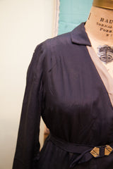 Art deco belt buckle and refined shoulder pleats on the navy blue 1920s day dress.