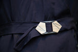 Geometric art deco buckle on the navy blue day dress belt.
