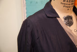 Close-up of vintage navy blue day dress shoulder showing delicate fabric striations.