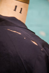 Close-up of vintage 1920s navy blue day dress shoulder showing tears and striations.