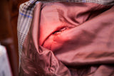 Vintage peplum top's interior lining, revealing rust-colored fabric with armpit fading and wear.