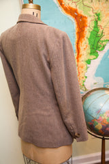 Light brown vintage wool blazer, showing subtle texture, curved hem, and cuff button.