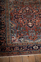 Detailed floral bouquets and hand-knotted texture on a vintage Persian Heriz rug's corner.