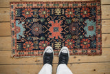 Aged edge of an antique Senneh rug with fine weave and gem-tone patterned motifs.