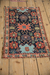 Tattered ends and classic madder root red border of an antique Persian Senneh rug.