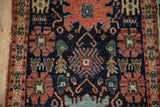 Antique Senneh rug's Harshang design with navy, madder red, and emerald green finned blossoms.