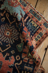 Finely woven antique Senneh rug with intricate Harshang motif, rich madder root and navy tones.