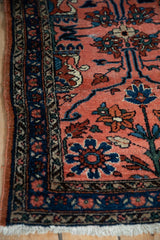 Corner view of a vintage Lilihan rug showing its intricate navy floral border and ivory fringe.