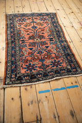 Angled view of a vintage Lilihan rug with scrolling blossoms on a dusty blush field.