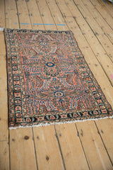 Vintage Lilihan rug's end with light tatter to fringe and dusty rose, navy floral border.