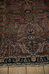 Hand-knotted Lilihan rug's lower border, with dark navy, blush, and blue motifs and fringe.