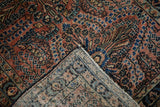 Vintage Lilihan rug's dusty rose and sapphire blue millefleur, showing hand-knotted reverse.
