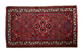 Vintage Hamadan rug with ruby red field, quatrefoil medallion, partial Herati design, gem tones.