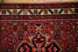 Ruby red field of vintage Hamadan rug showing intricate Herati motif and blossom border.