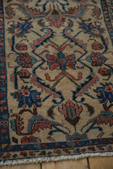 Antique Lilihan rug close-up: hand-knotted floral vines, serrated leaves, ivory ground, and fringe.