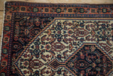 Corner detail of a vintage Senneh rug showing the stepped spandrel and Herati motif.